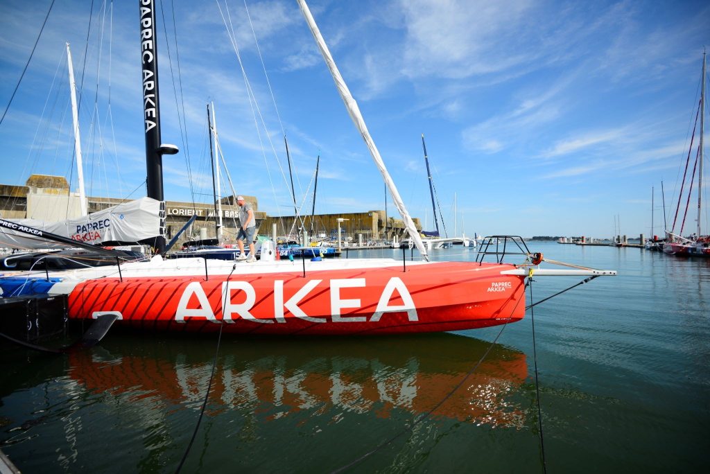 Barco IMOCA que participa a regatas de vela en el puerto de Lorient La Base (Bretaña del Sur, Morbihan)